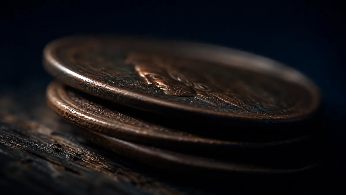 Worn copper tokens stacked on aged wood